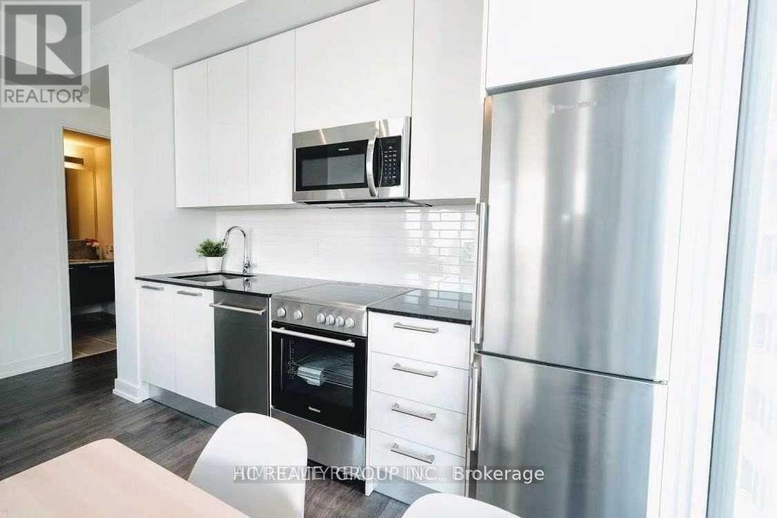 A modern kitchen with stainless steel appliances and white cabinets.