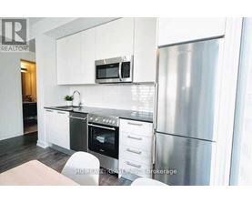 A modern kitchen with stainless steel appliances and white cabinets.