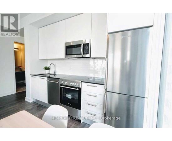 A modern kitchen with stainless steel appliances and white cabinets.