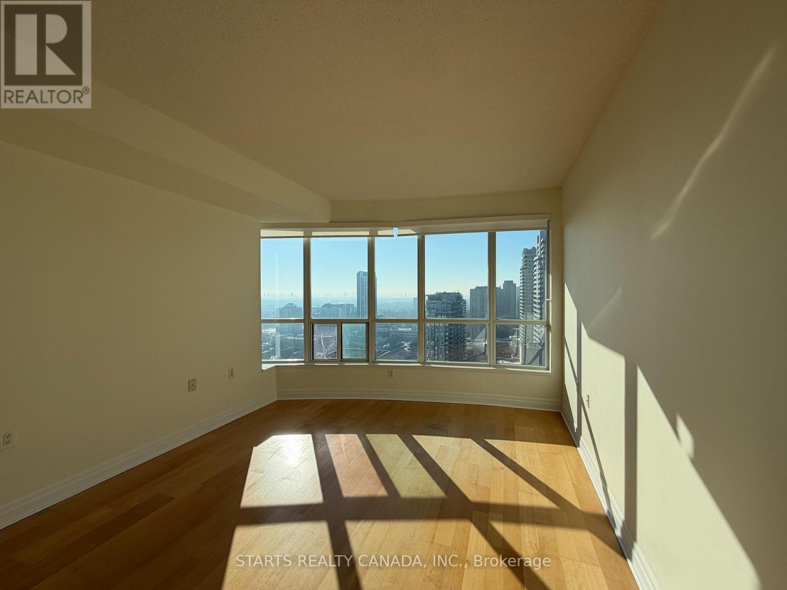 A room with a large window overlooking a cityscape.