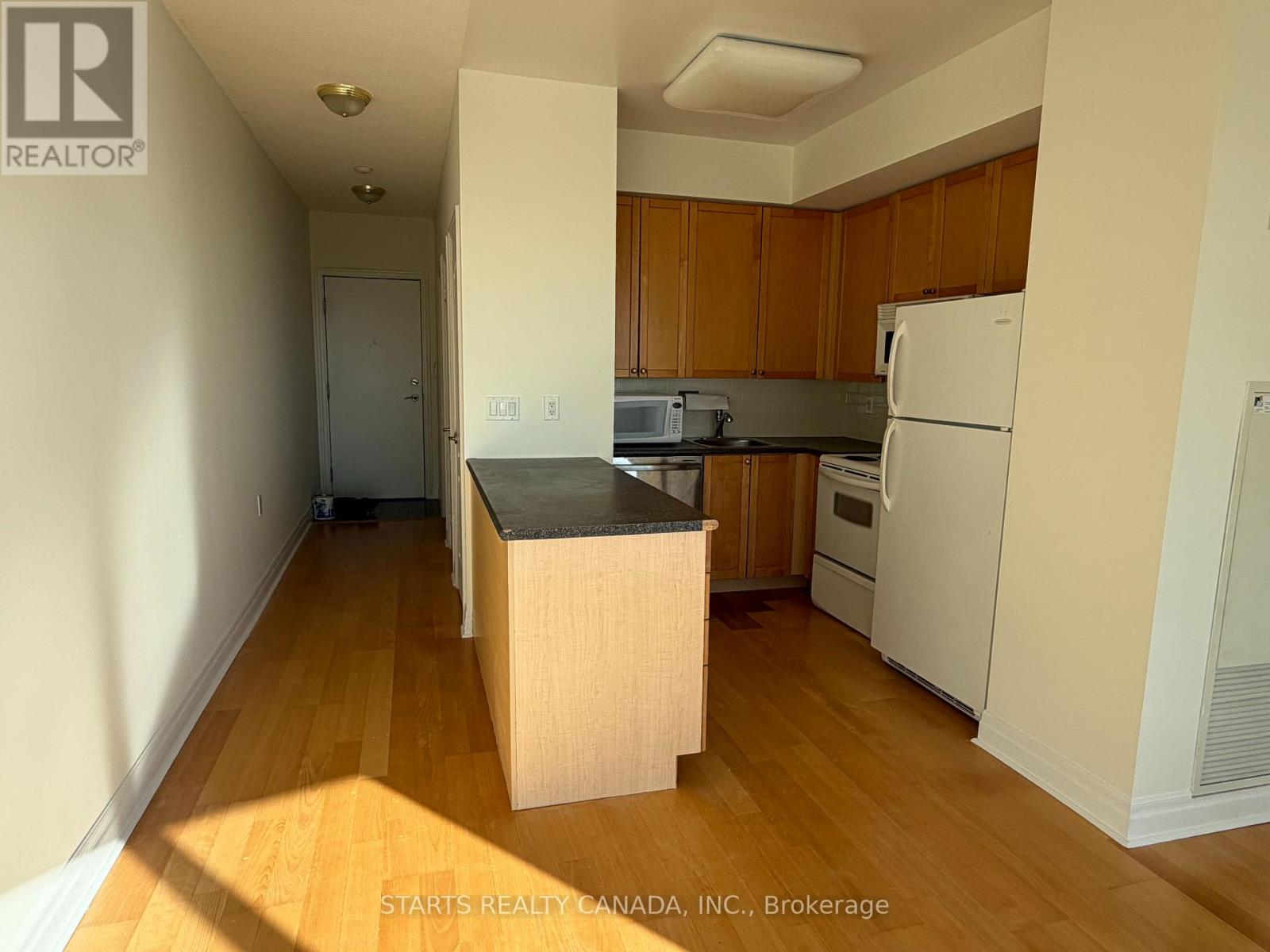 A kitchen with wooden cabinets and a white refrigerator.