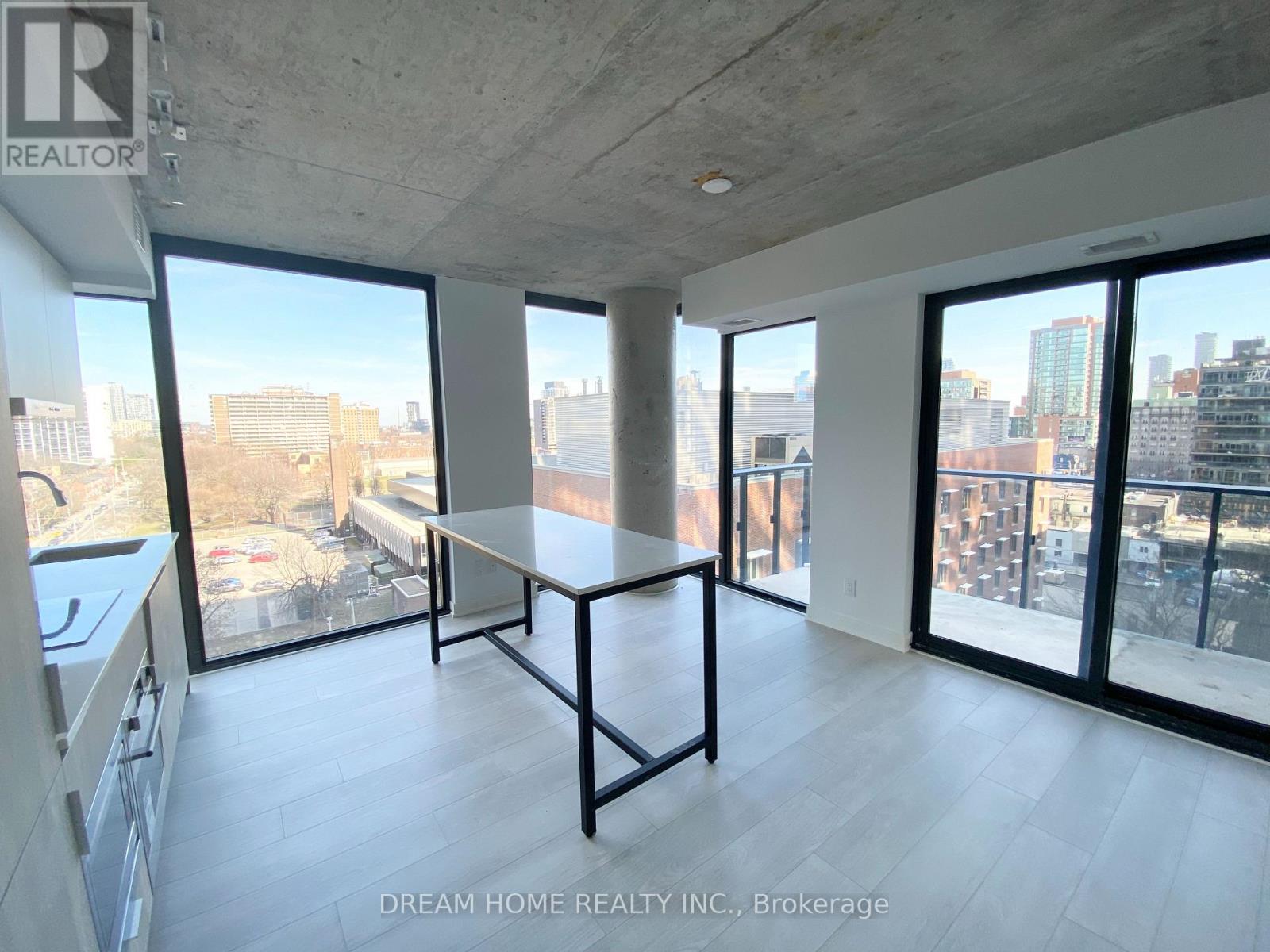 A large, empty room with a table and a view of the city.