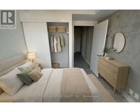 A bedroom with a large bed, a wooden dresser, and a mirror on the wall.