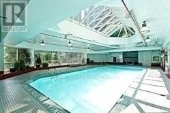 A large indoor swimming pool with a wooden deck.
