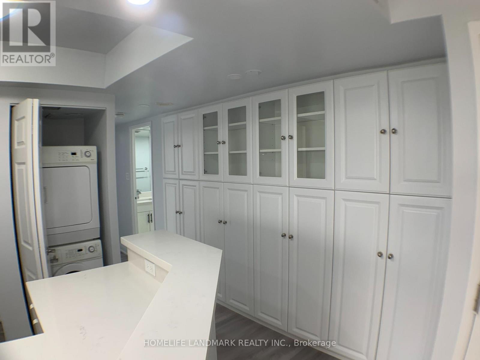 A white kitchen with cabinets and a counter.