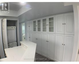 A white kitchen with cabinets and a counter.