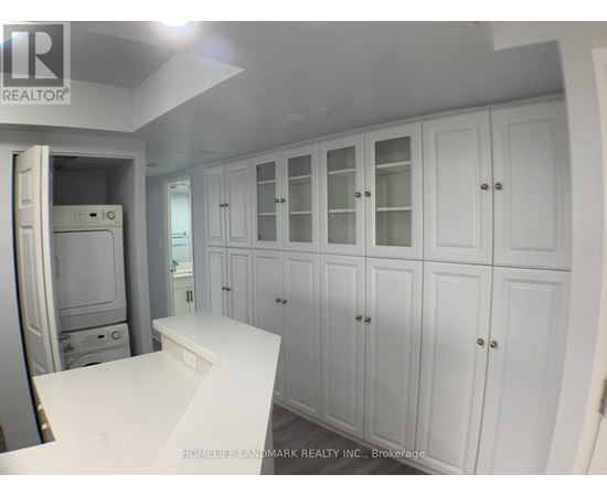 A white kitchen with cabinets and a counter.