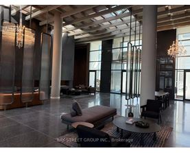A spacious lobby with a chandelier, sofas, and a coffee table.