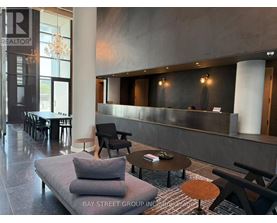 A modern waiting area with a grey sofa and wooden coffee table.