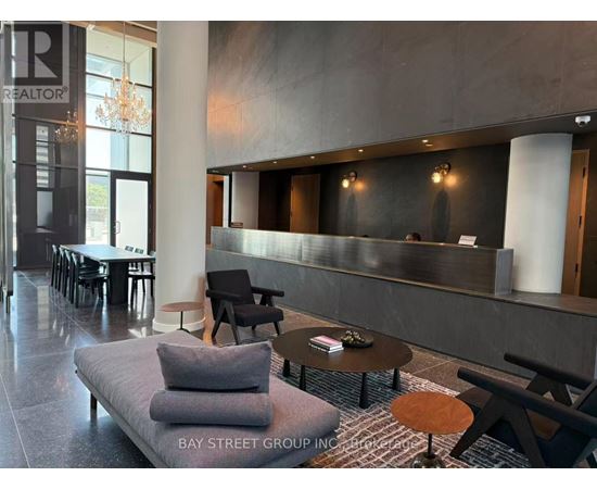 A modern waiting area with a grey sofa and wooden coffee table.