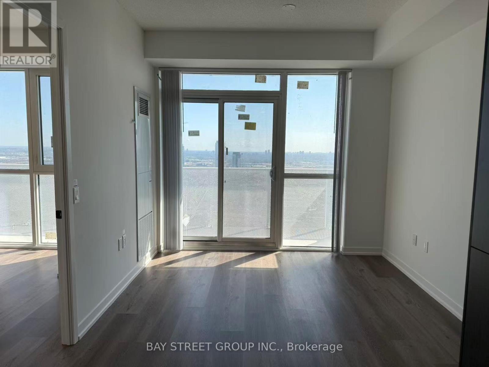 A room with a view of the beach through the sliding glass doors.