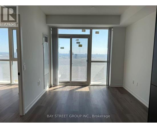 A room with a view of the beach through the sliding glass doors.
