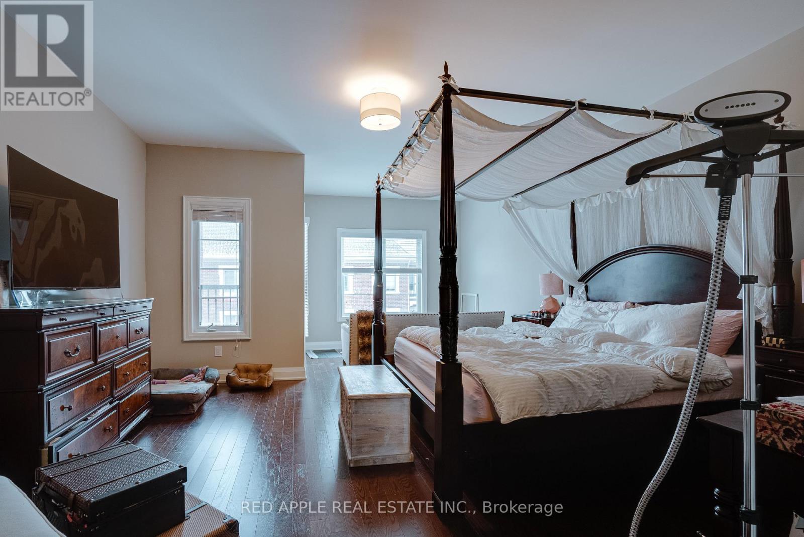 A bedroom with a four poster bed and a dresser.