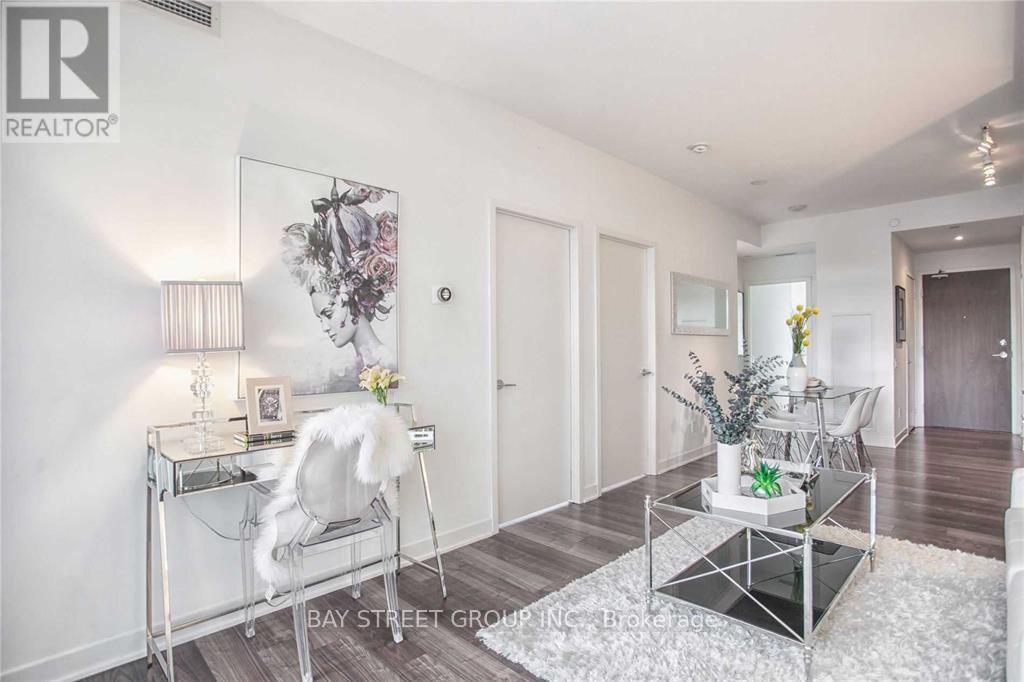 A living room with a glass coffee table and a white chair.