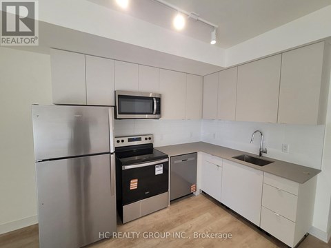 A kitchen with white cabinets and a stainless steel refrigerator.