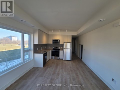 A spacious kitchen with a refrigerator, oven, and microwave.