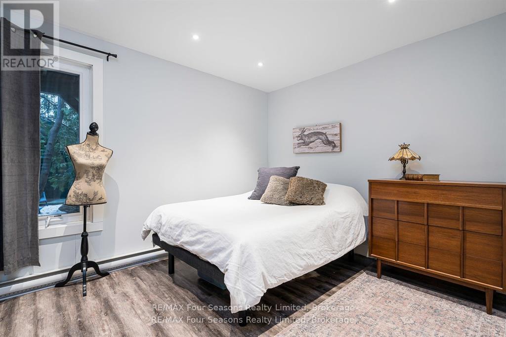 A bedroom with a white bed and a wooden dresser.
