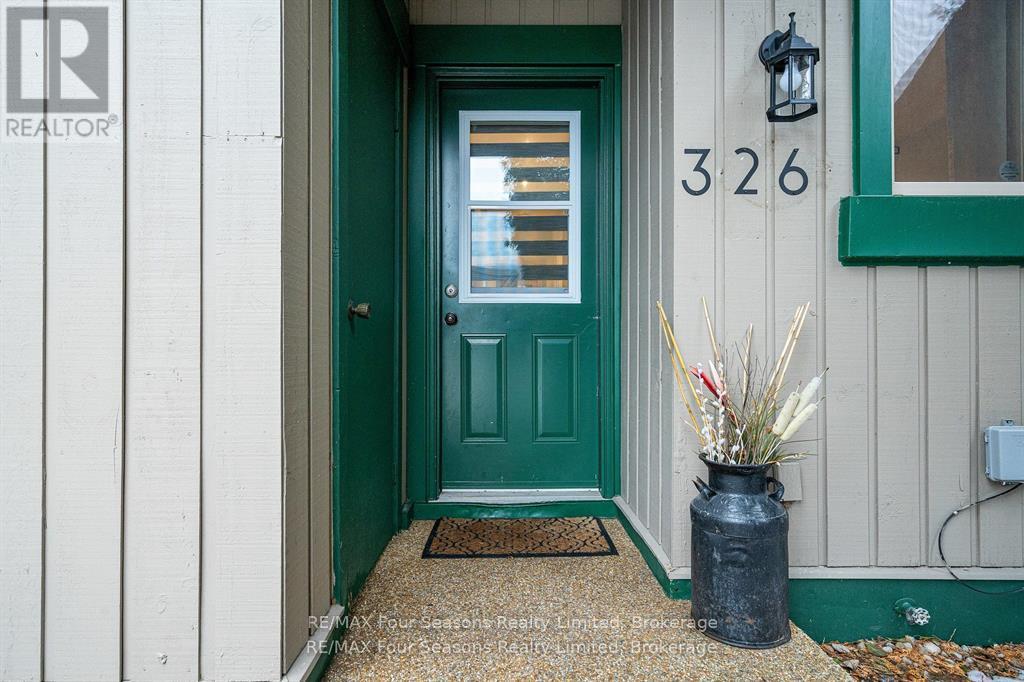 A green door with a number 326 on the wall above it.