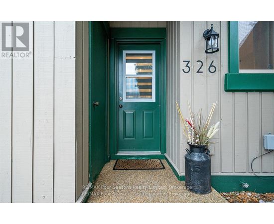 A green door with a number 326 on the wall above it.