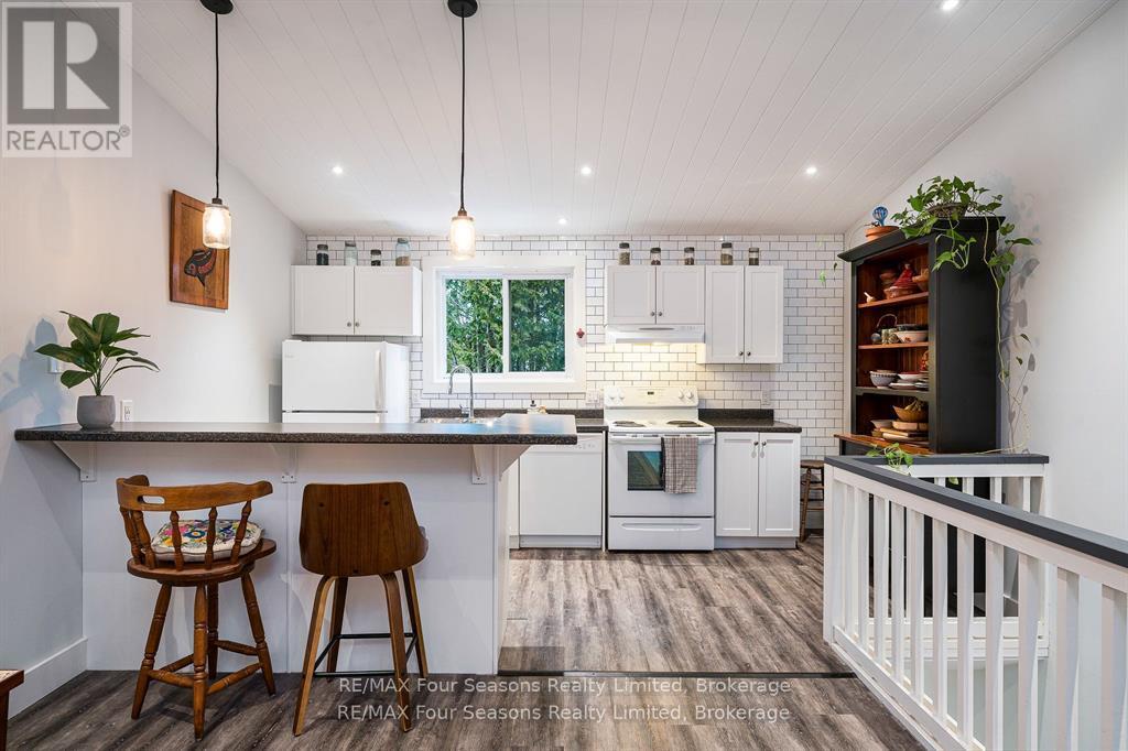 A kitchen with white cabinets and a wooden bar stool.