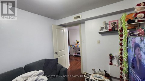 A living room with a couch and a doorway leading to another room.