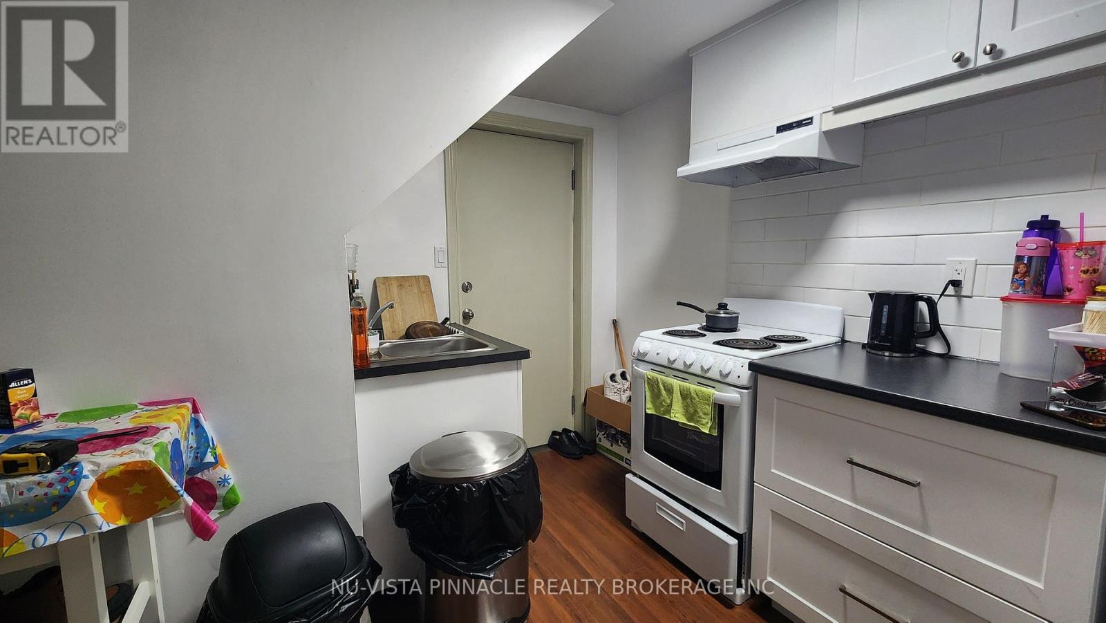A kitchen with a stove, oven, and a table with a chair.