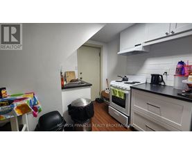 A kitchen with a stove, oven, and a table with a chair.
