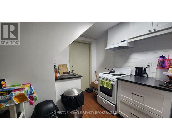 A kitchen with a stove, oven, and a table with a chair.