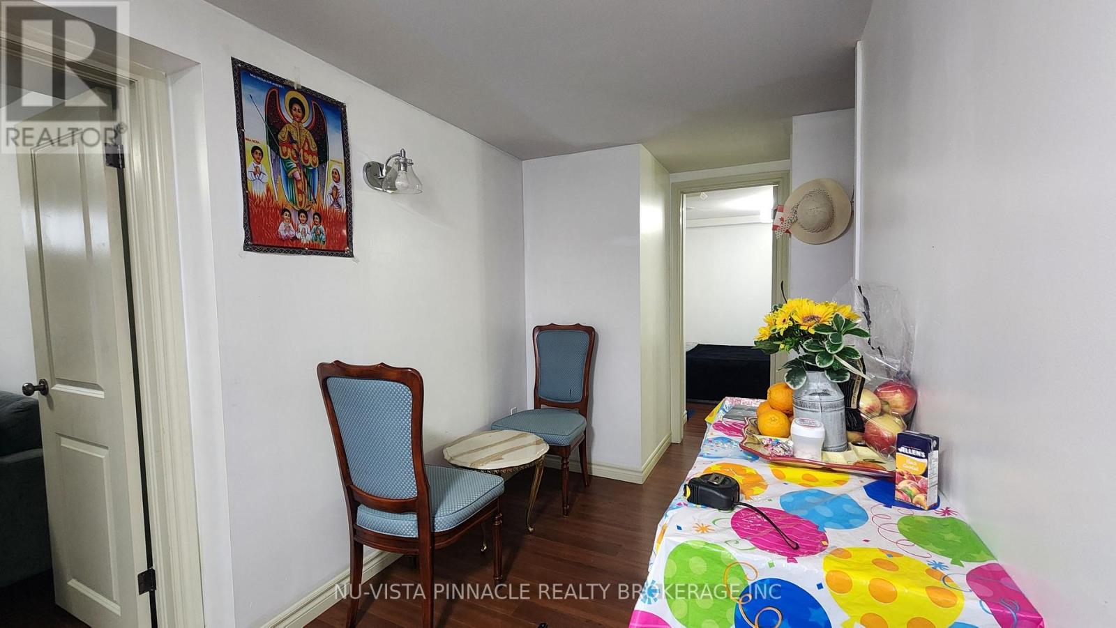 A dining room with a table set for two and a painting on the wall.