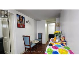 A dining room with a table set for two and a painting on the wall.