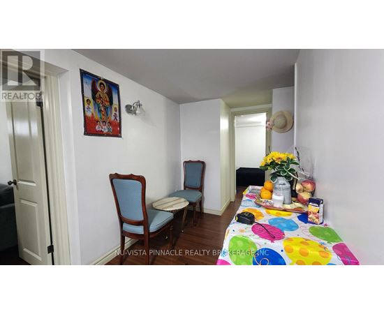A dining room with a table set for two and a painting on the wall.