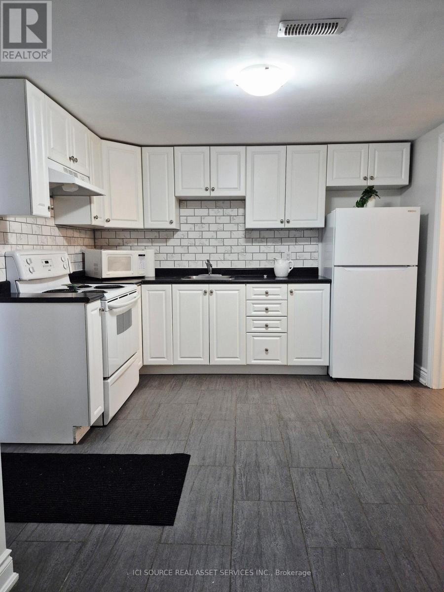 A kitchen with white appliances and cabinets.