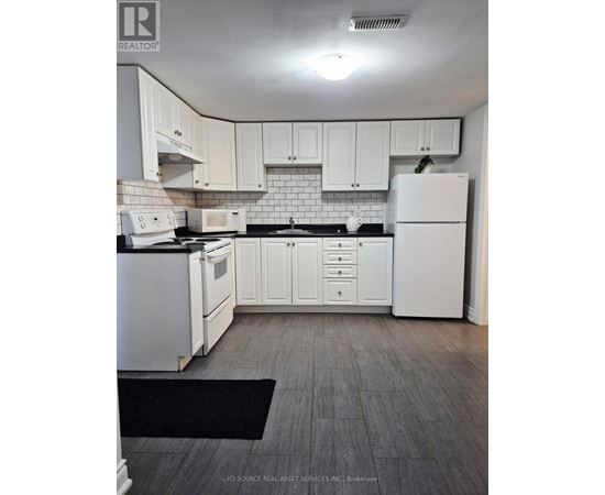 A kitchen with white appliances and cabinets.