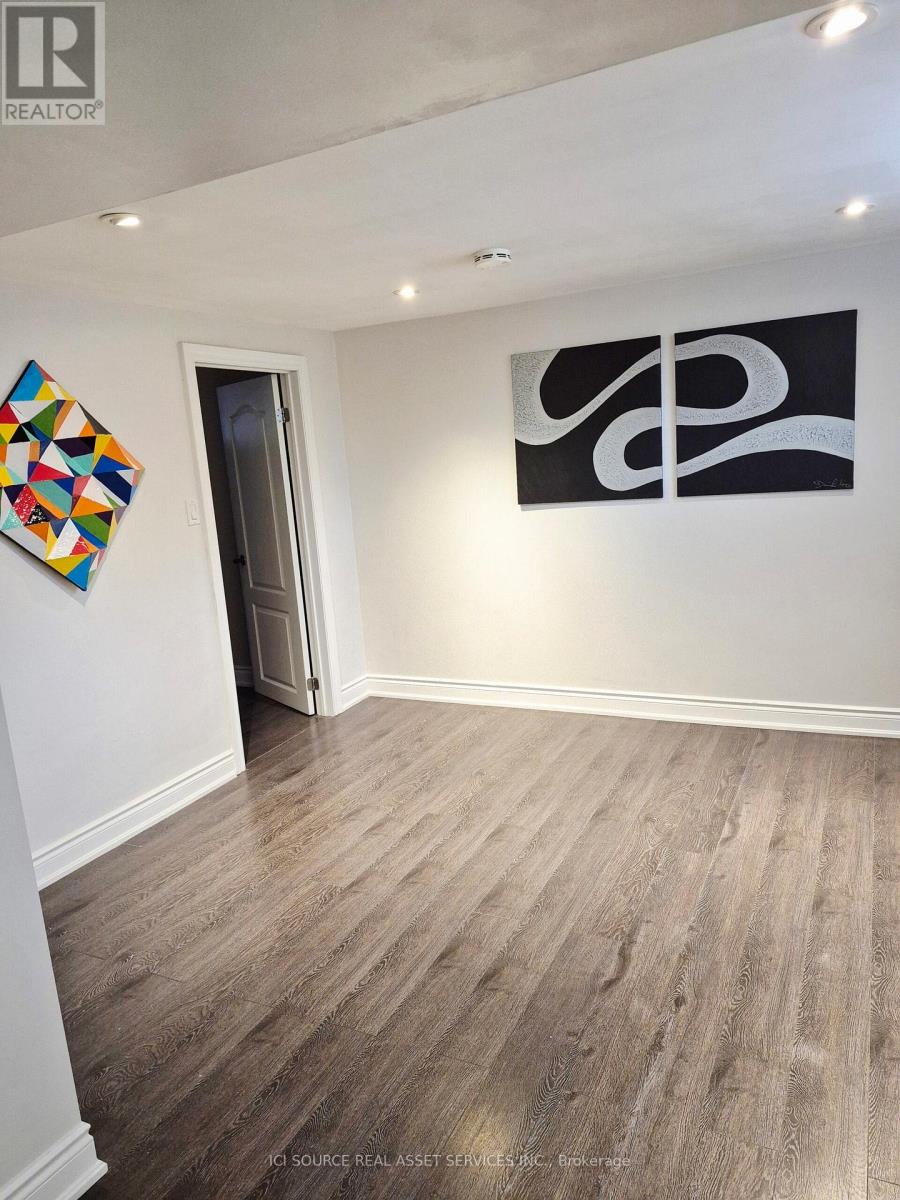 A room with a wooden floor and a painting on the wall.