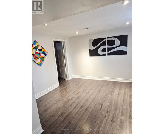 A room with a wooden floor and a painting on the wall.