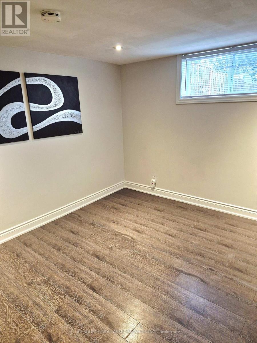 A room with a wooden floor and a large painting on the wall.