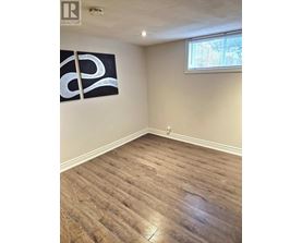 A room with a wooden floor and a large painting on the wall.