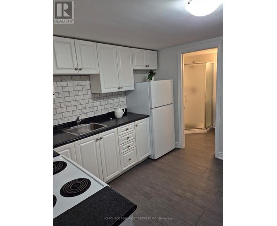 A kitchen with white cabinets and a black countertop.