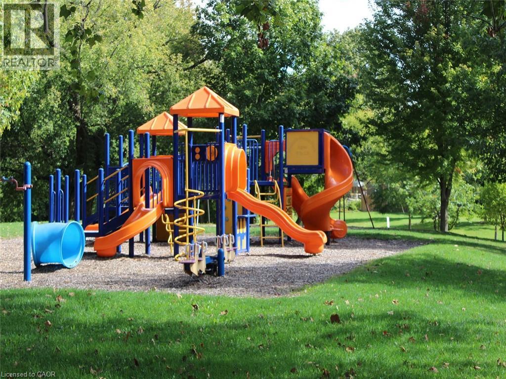 A playground with a blue and orange slide and a yellow staircase.