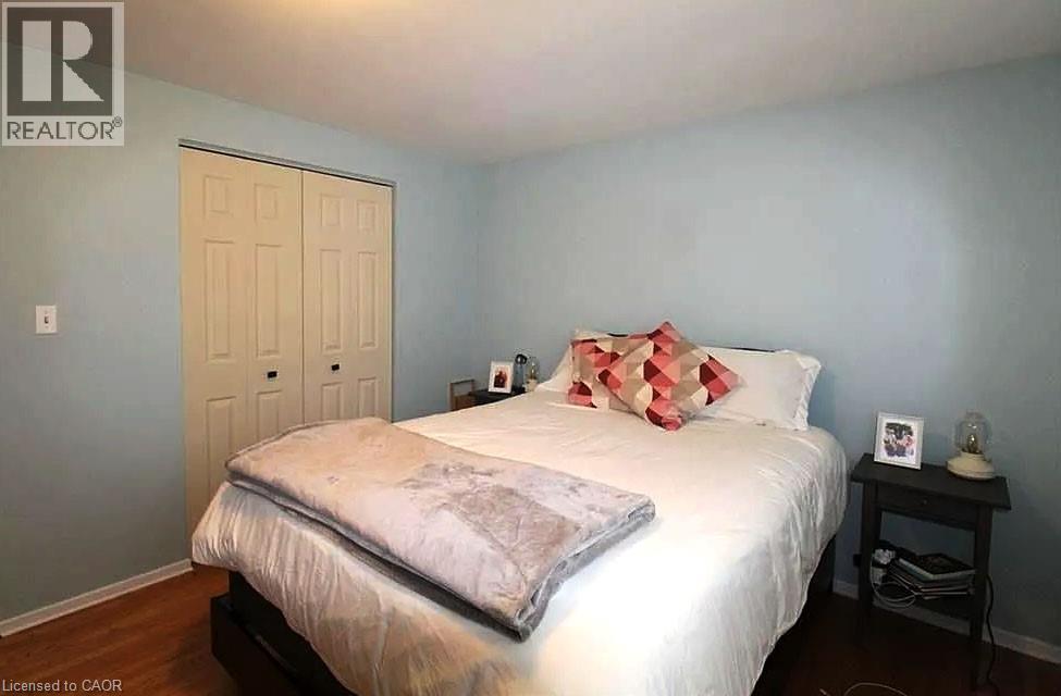A bedroom with a bed, nightstand, and a door.