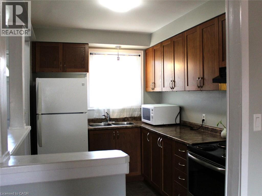 A kitchen with a white refrigerator and wooden cabinets.