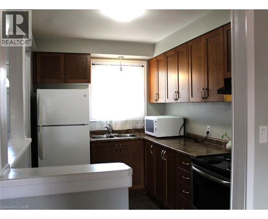 A kitchen with a white refrigerator and wooden cabinets.
