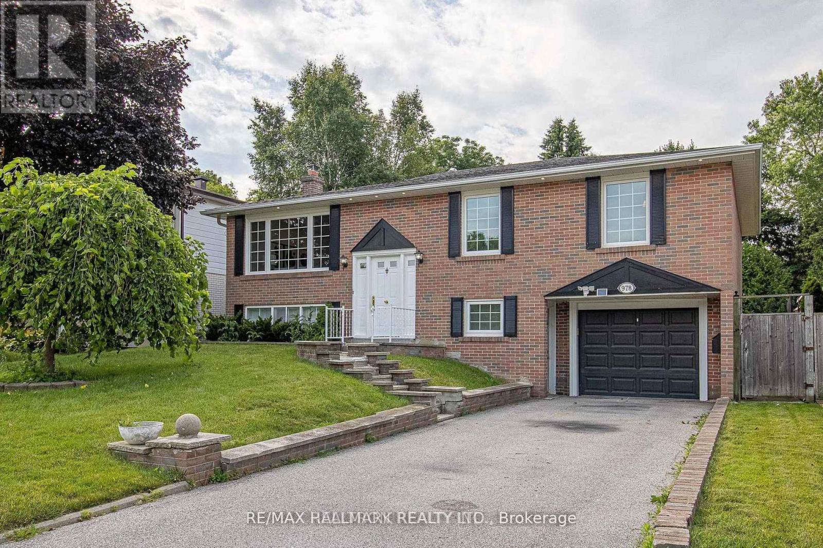 A house with a brick facade and a white garage door is for sale.