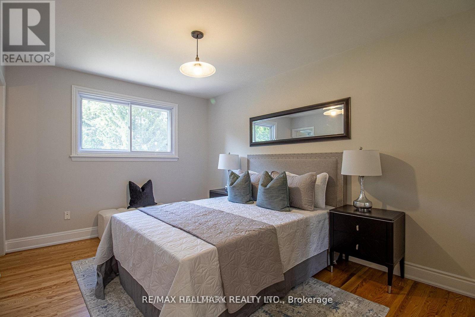 A bedroom with a bed, nightstand, and lamp.