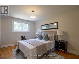 A bedroom with a bed, nightstand, and lamp.