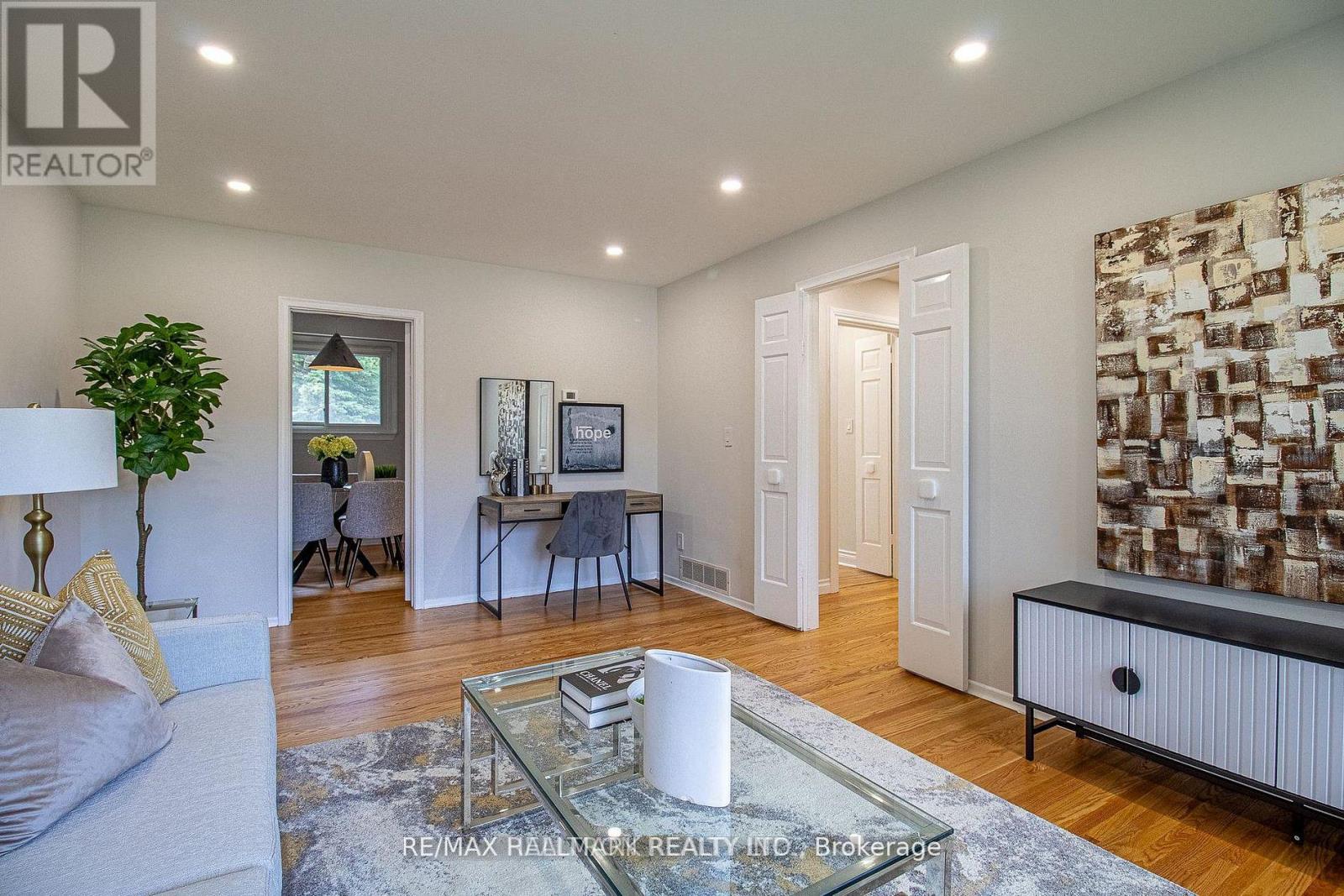 A living room with a glass coffee table and a white sofa.
