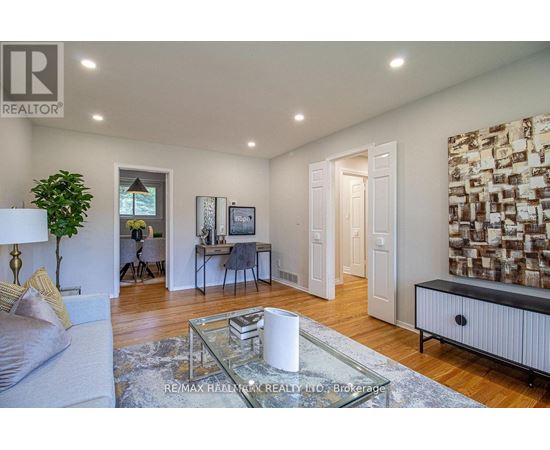 A living room with a glass coffee table and a white sofa.