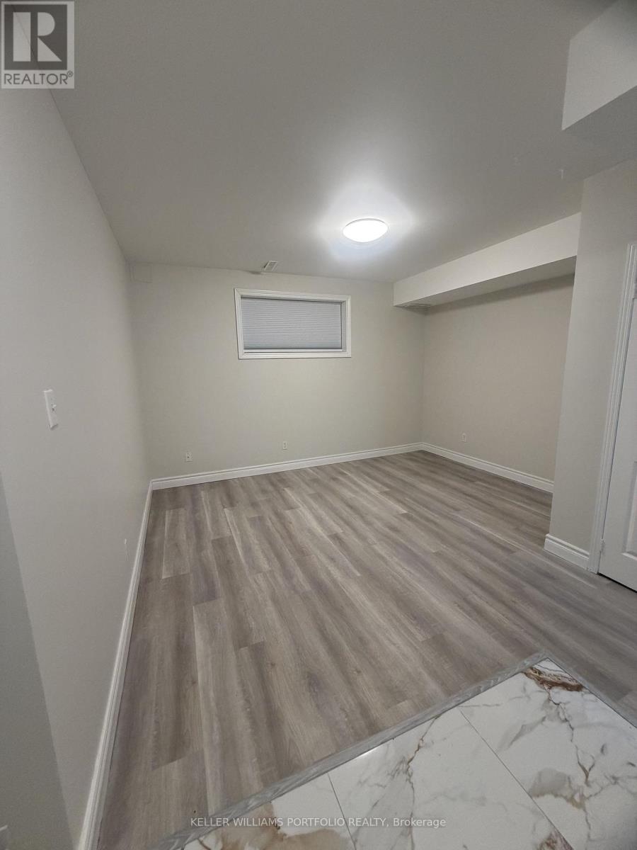 A room with wooden flooring and a window.