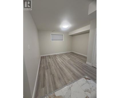 A room with wooden flooring and a window.