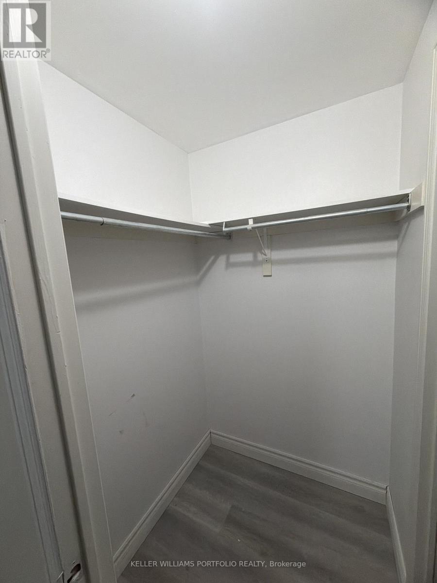A small, empty walk-in closet with a grey carpet.